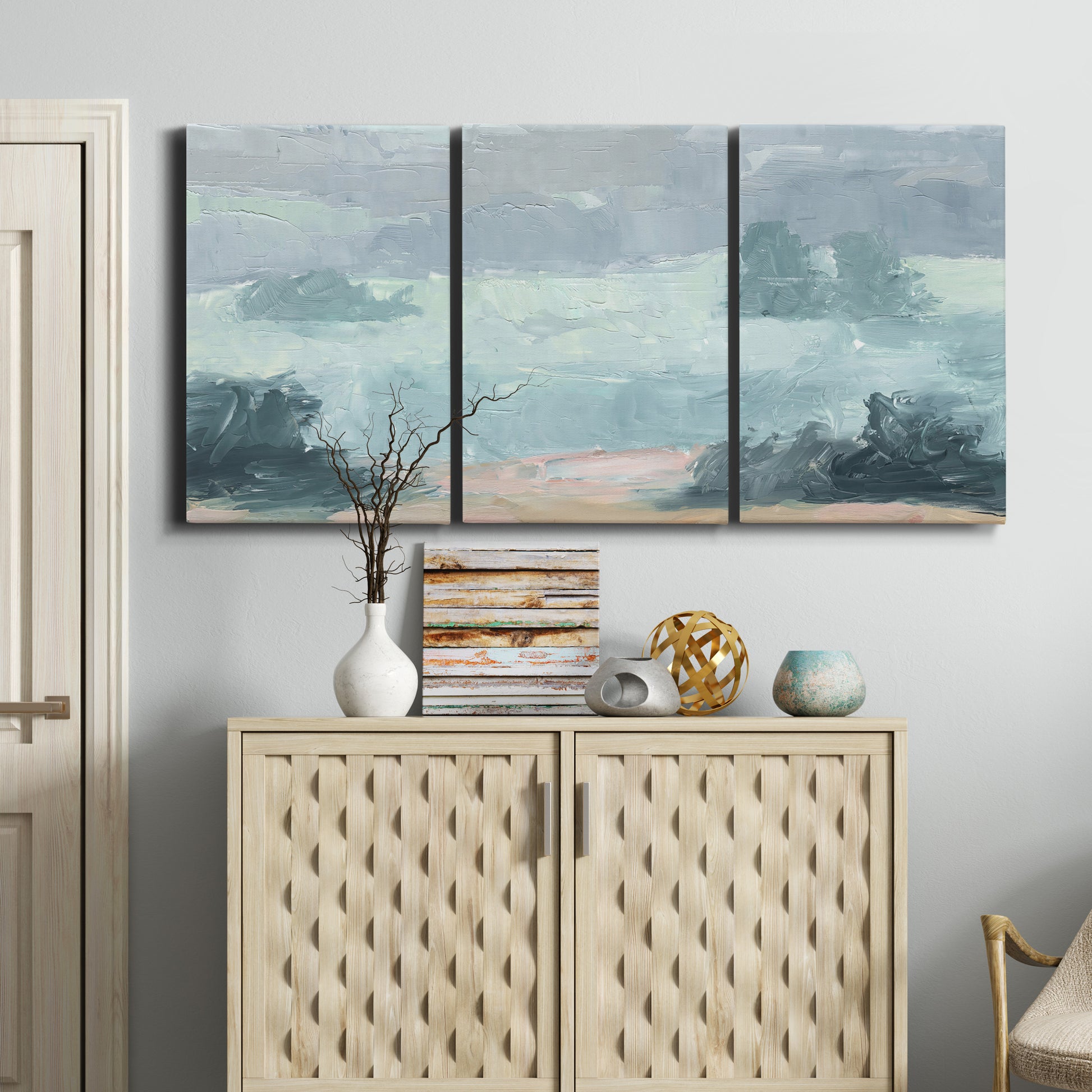 Three-panel canvas wall art featuring soft pastel valley landscape, displayed above a cabinet in an entryway.