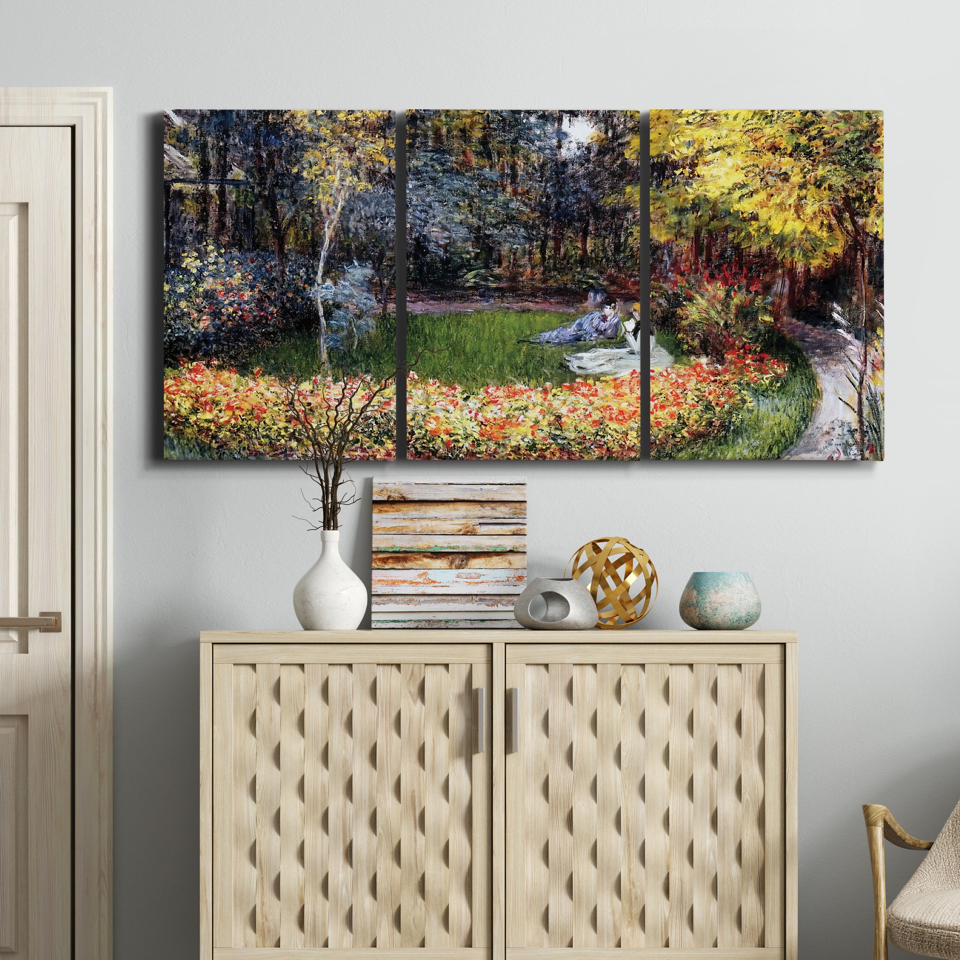 Three-panel canvas wall art featuring garden in full bloom by coast, displayed above a cabinet in an entryway.
