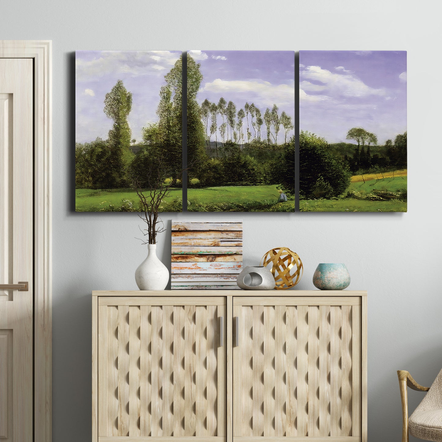 Three-panel canvas wall art featuring open landscape near le havre, displayed above a cabinet in an entryway.