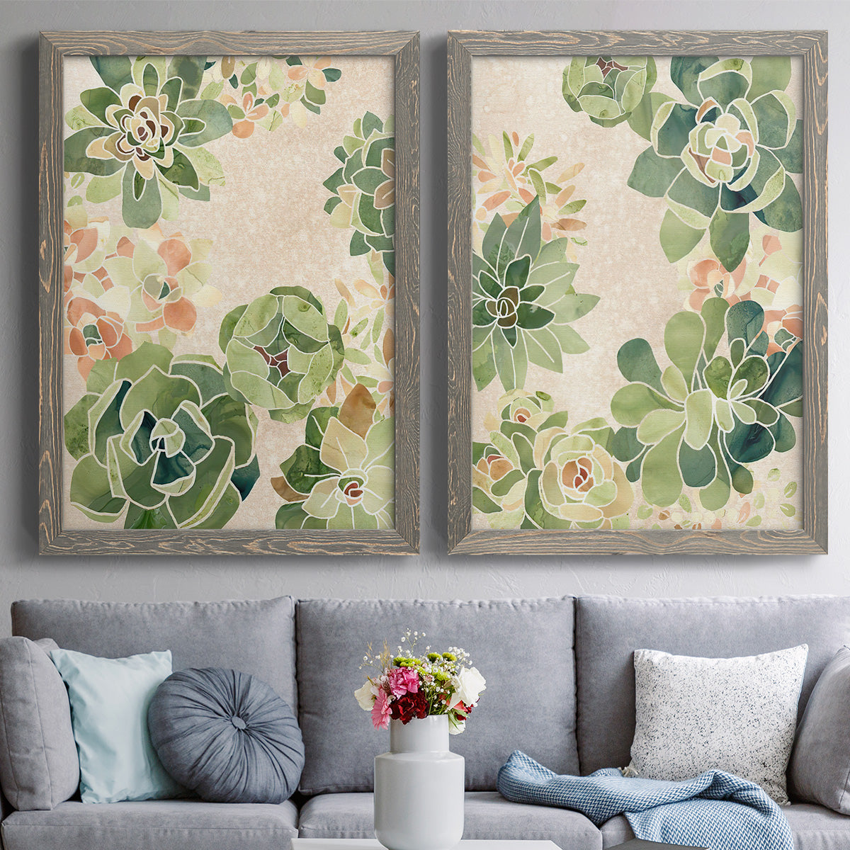Set of two gray barnwood framed canvas prints depicting paired decorative botanical pattern prints with green rosettes, peach blossoms, and mosaic-like outlines above a sofa in a contemporary living room.