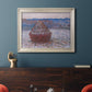 Impressionist single haystack landscape by Claude Monet in an ornate champagne frame displayed in a dark-toned interior setting.