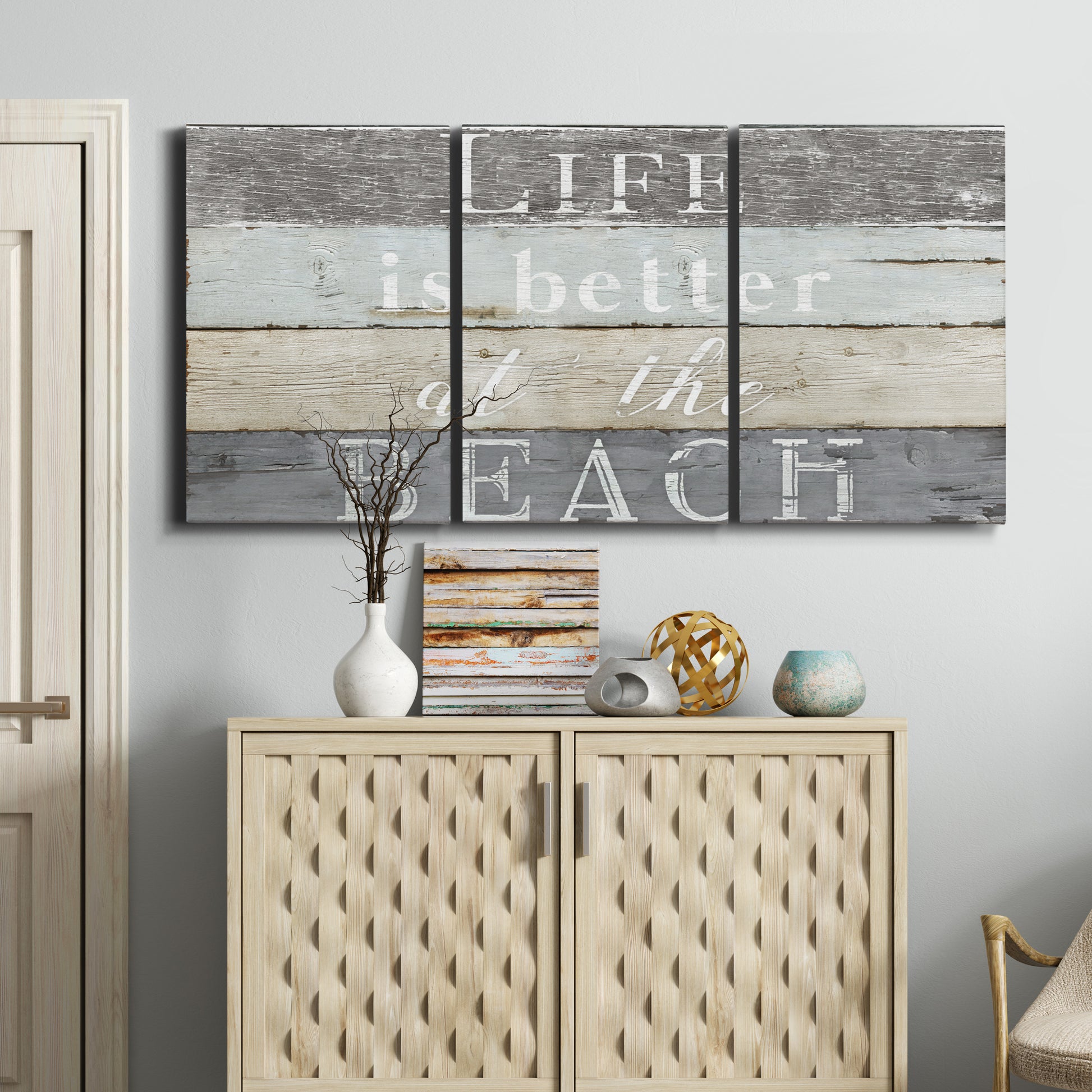 Three-panel canvas wall art featuring beach themed typography design, displayed above a cabinet in an entryway.