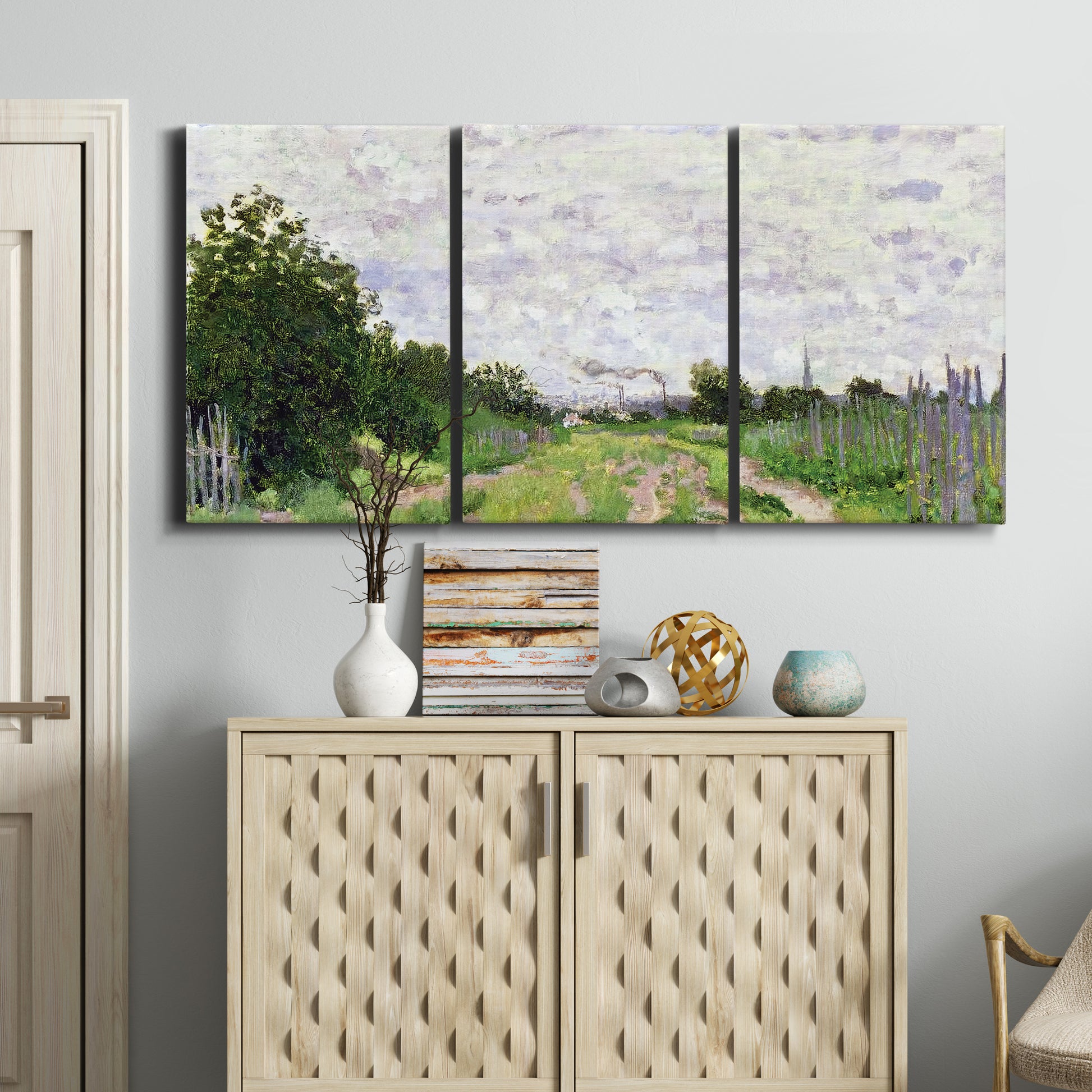 Three-panel canvas wall art featuring spring landscape with blossoming trees, displayed above a cabinet in an entryway.