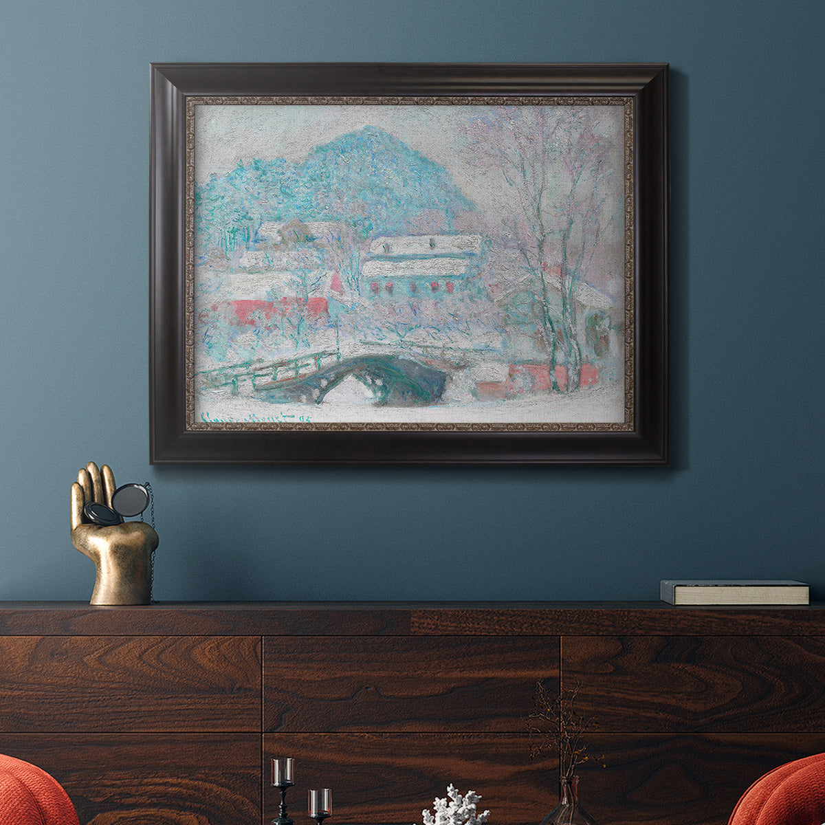 Impressionist coastal village landscape in Norway by Claude Monet in an ornate black frame with gilded inner detail displayed in a dark-toned interior setting.