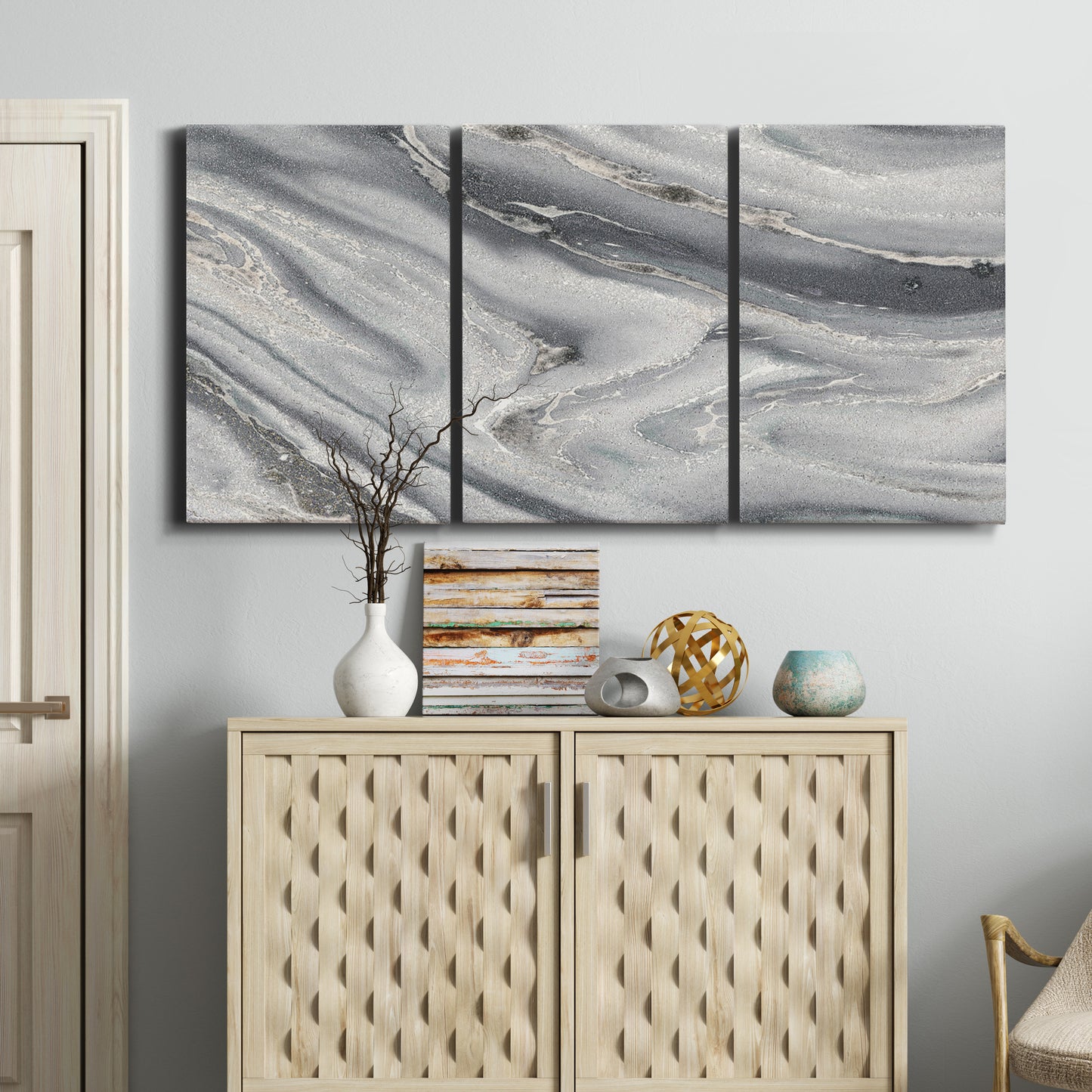 Three-panel canvas wall art featuring minimal monochrome abstract forms, displayed above a cabinet in an entryway.