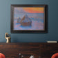Impressionist haystack scene at sunset by Claude Monet in an ornate black frame with gilded inner detail displayed in a dark-toned interior setting.