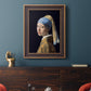 Iconic portrait of a girl wearing a pearl earring by Johannes Vermeer in an ornate bronzed mahogany wood frame displayed in a dark-toned interior setting.