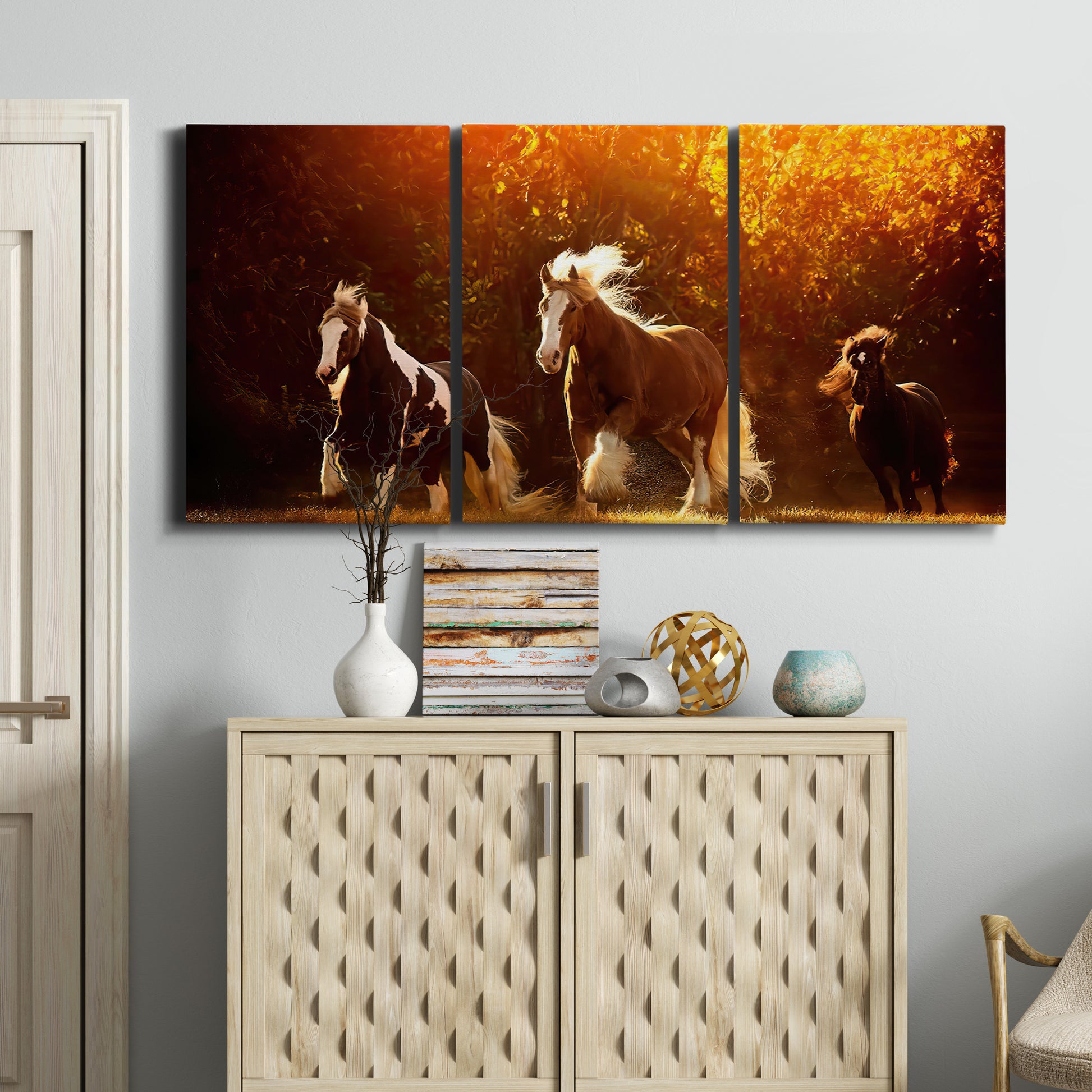 Three-panel canvas wall art featuring running horses across open field, displayed above a cabinet in an entryway.