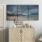 Three-panel canvas wall art featuring stormy sea glass toned coastline, displayed above a cabinet in an entryway.