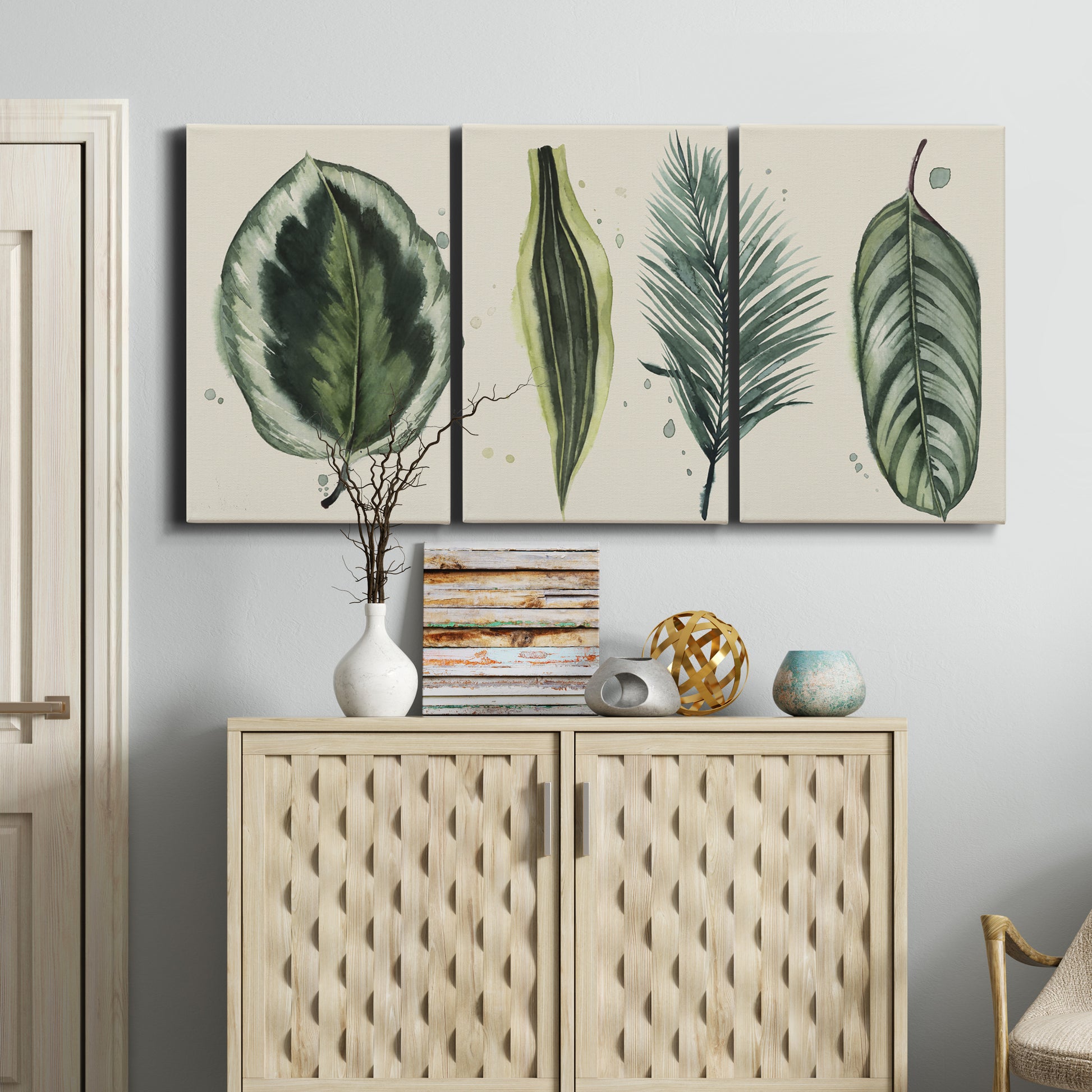 Three-panel canvas wall art featuring botanical palm leaf illustration, displayed above a cabinet in an entryway.