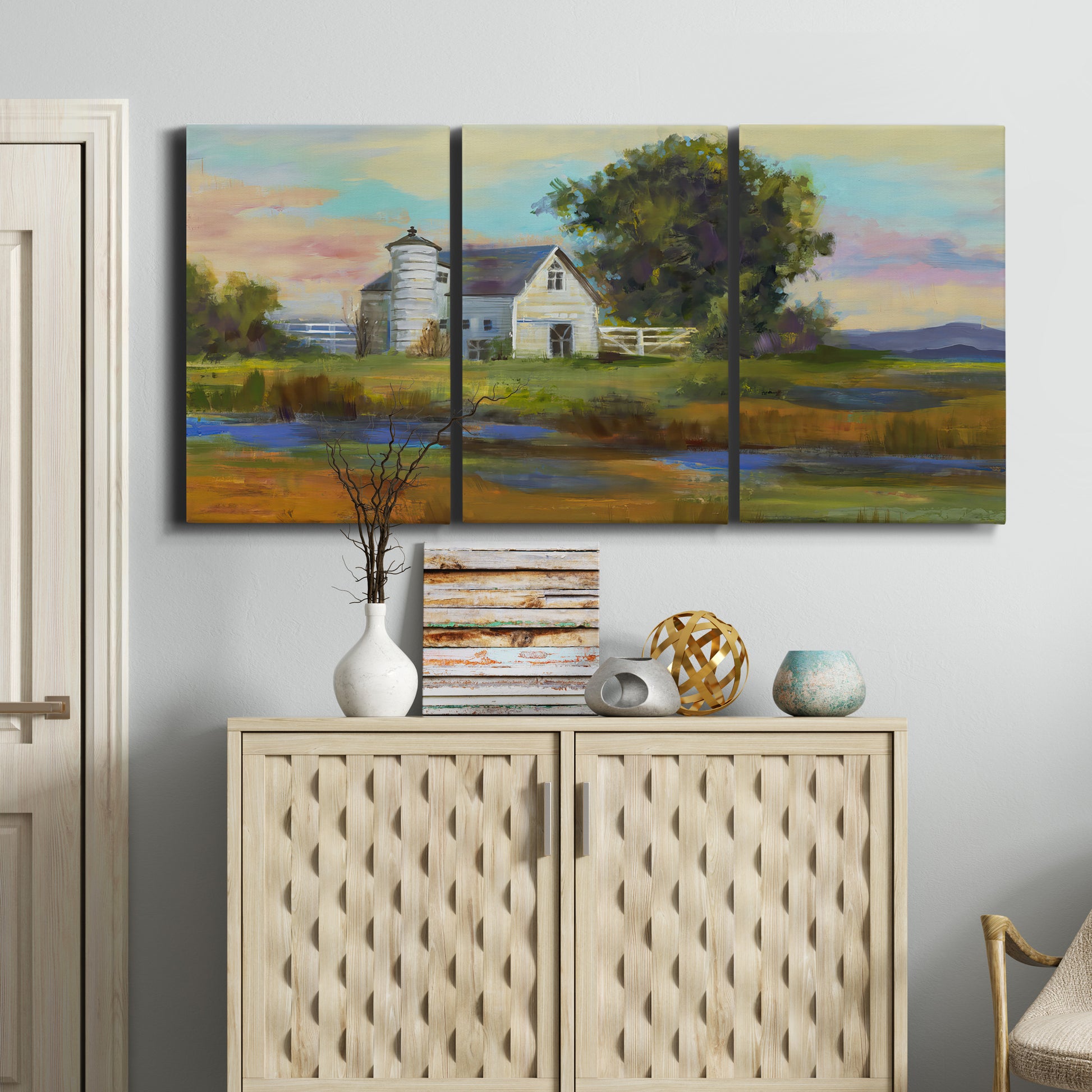 Three-panel canvas wall art featuring rural barn landscape with fields, displayed above a cabinet in an entryway.