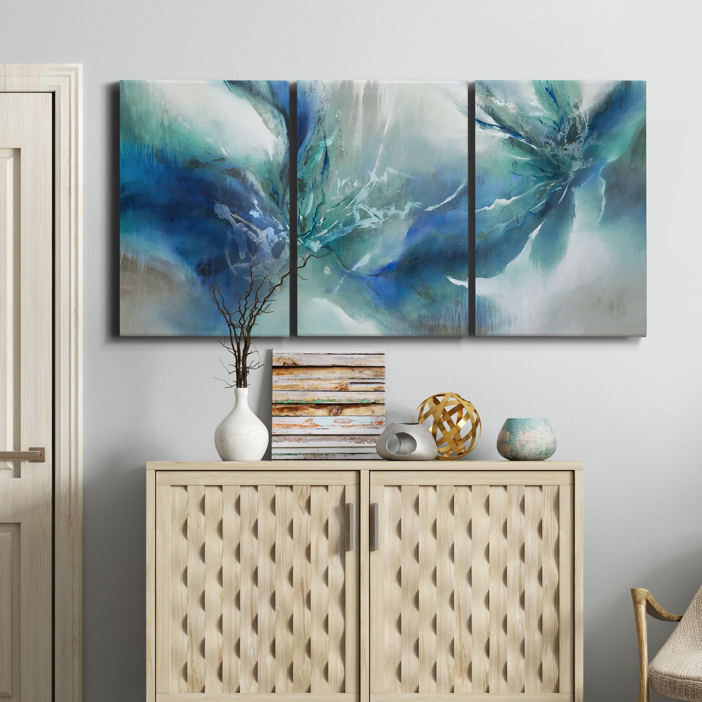 Three-panel canvas wall art featuring subtle abstract light flicker composition, displayed above a cabinet in an entryway.