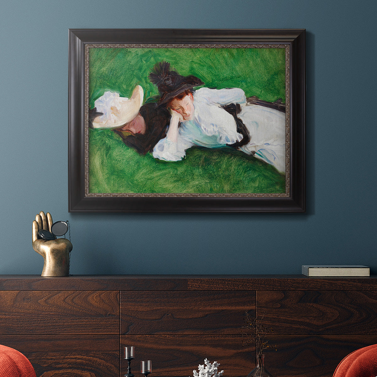Impressionist outdoor portrait of two girls by John Singer Sargent in an ornate black frame with gilded inner detail displayed in a dark-toned interior setting.