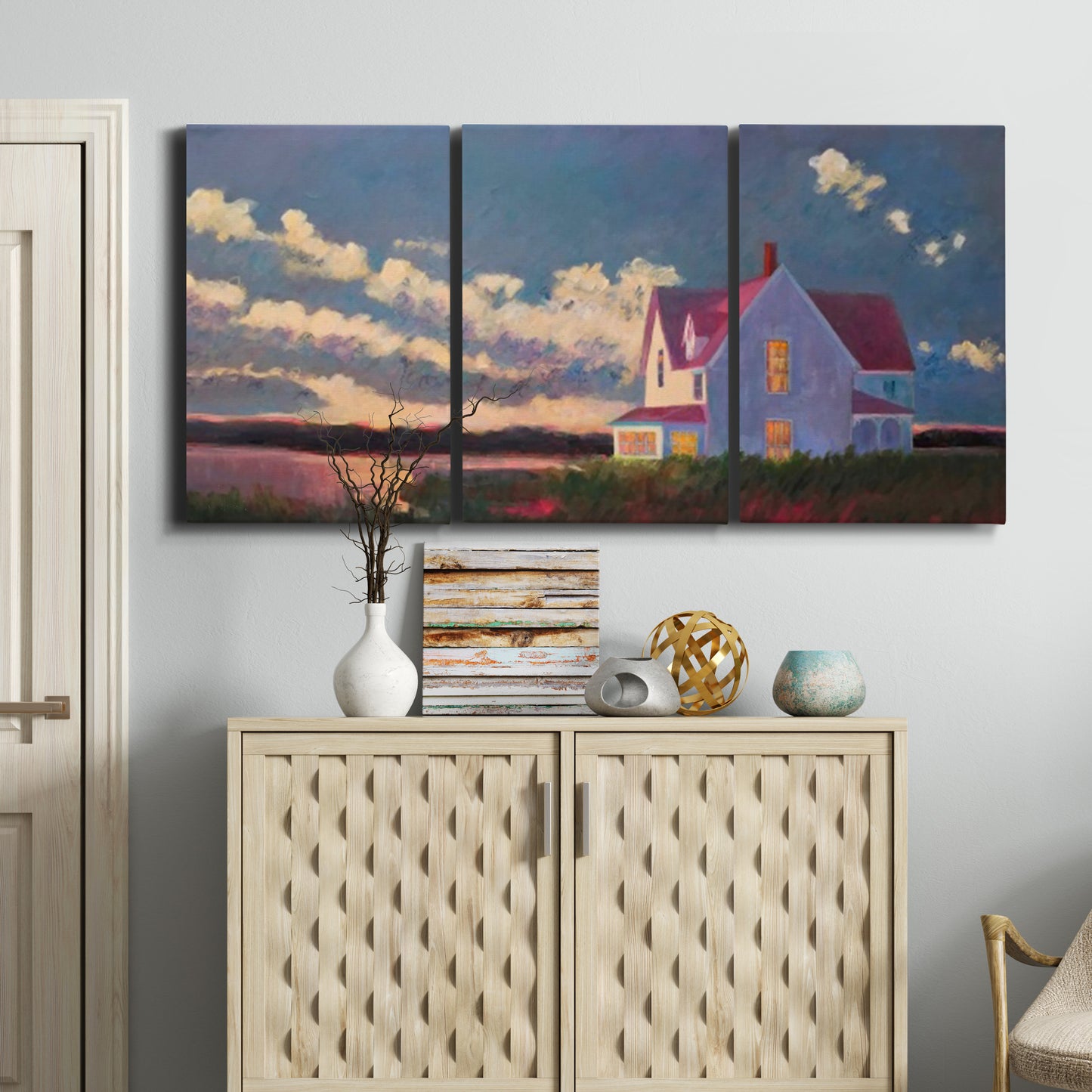 Three-panel canvas wall art featuring farmhouse scene before approaching storm, displayed above a cabinet in an entryway.