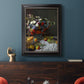 Impressionist floral still life painting by Claude Monet in an ornate black frame with gilded inner detail displayed in a dark-toned interior setting.