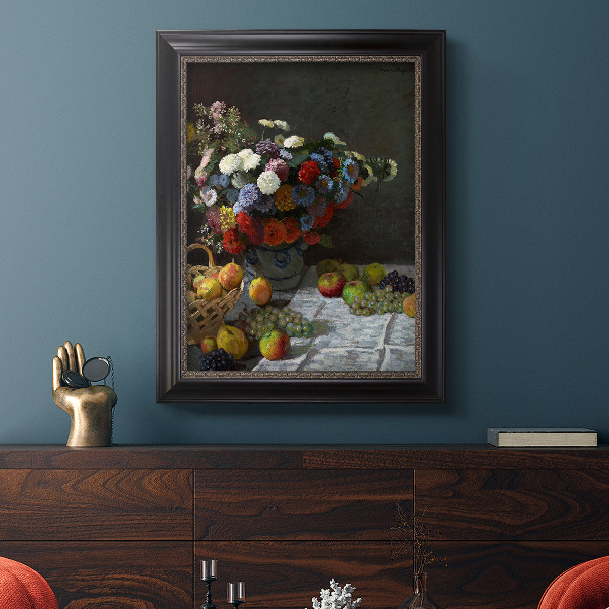 Impressionist floral still life painting by Claude Monet in an ornate black frame with gilded inner detail displayed in a dark-toned interior setting.