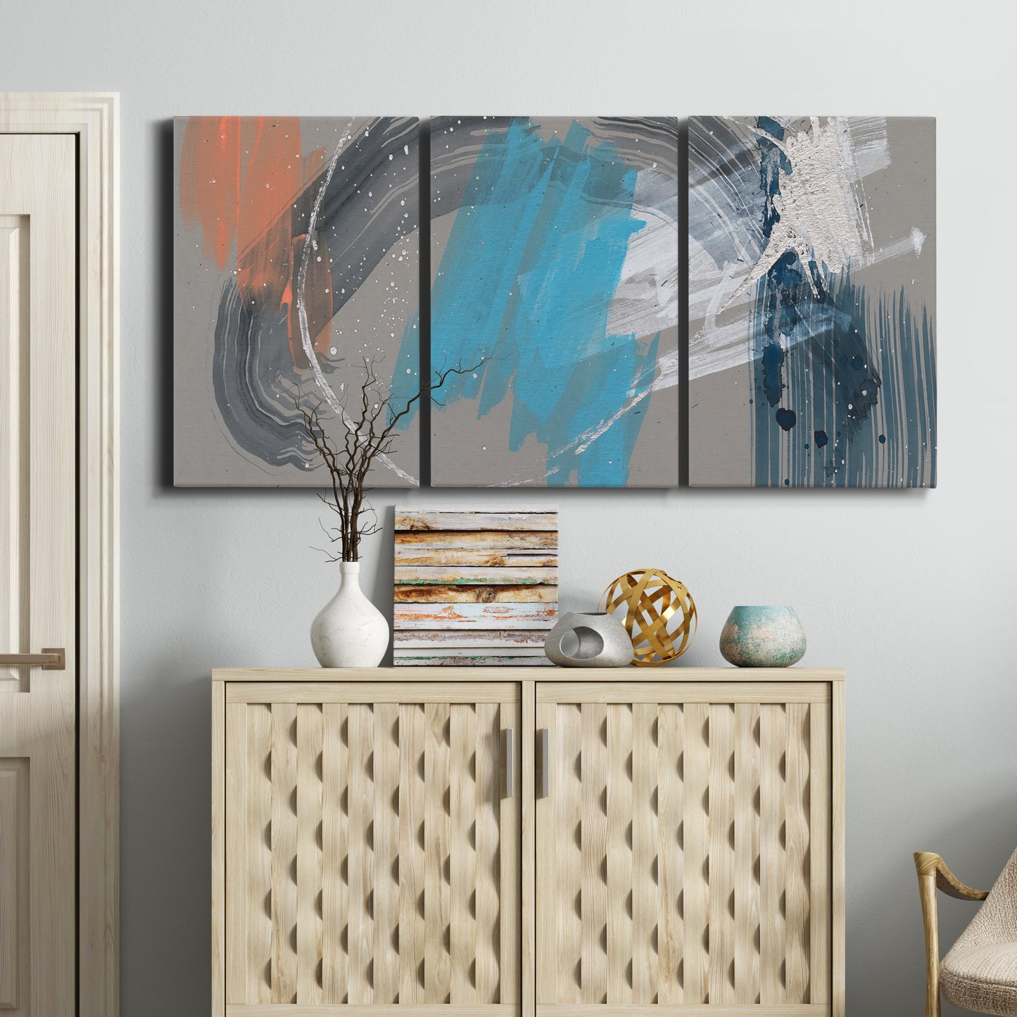 Three-panel canvas wall art featuring playful abstract mark making, displayed above a cabinet in an entryway.