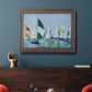 Coastal harbor watercolor painting in an ornate traditional bronze frame displayed in a dark-toned interior setting.