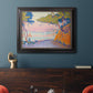 Pointillist coastal seascape by Paul Signac in an ornate black frame with gilded inner detail displayed in a dark-toned interior setting.