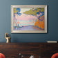 Pointillist coastal seascape by Paul Signac in an ornate champagne frame displayed in a dark-toned interior setting.