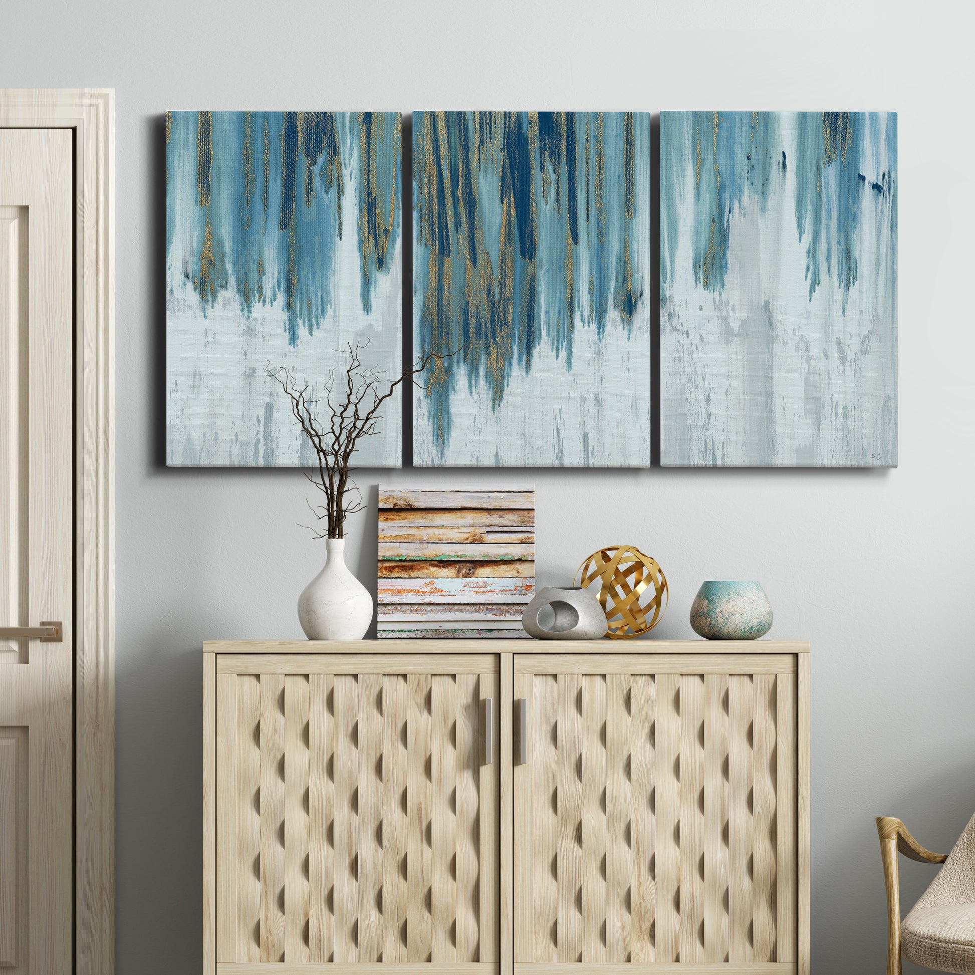 Three-panel canvas wall art featuring wide pastoral valley landscape, displayed above a cabinet in an entryway.