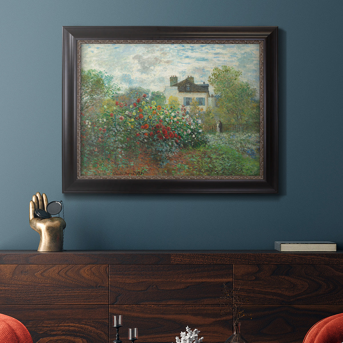 Impressionist garden landscape at Argenteuil by Claude Monet in an ornate black frame with gilded inner detail displayed in a dark-toned interior setting.