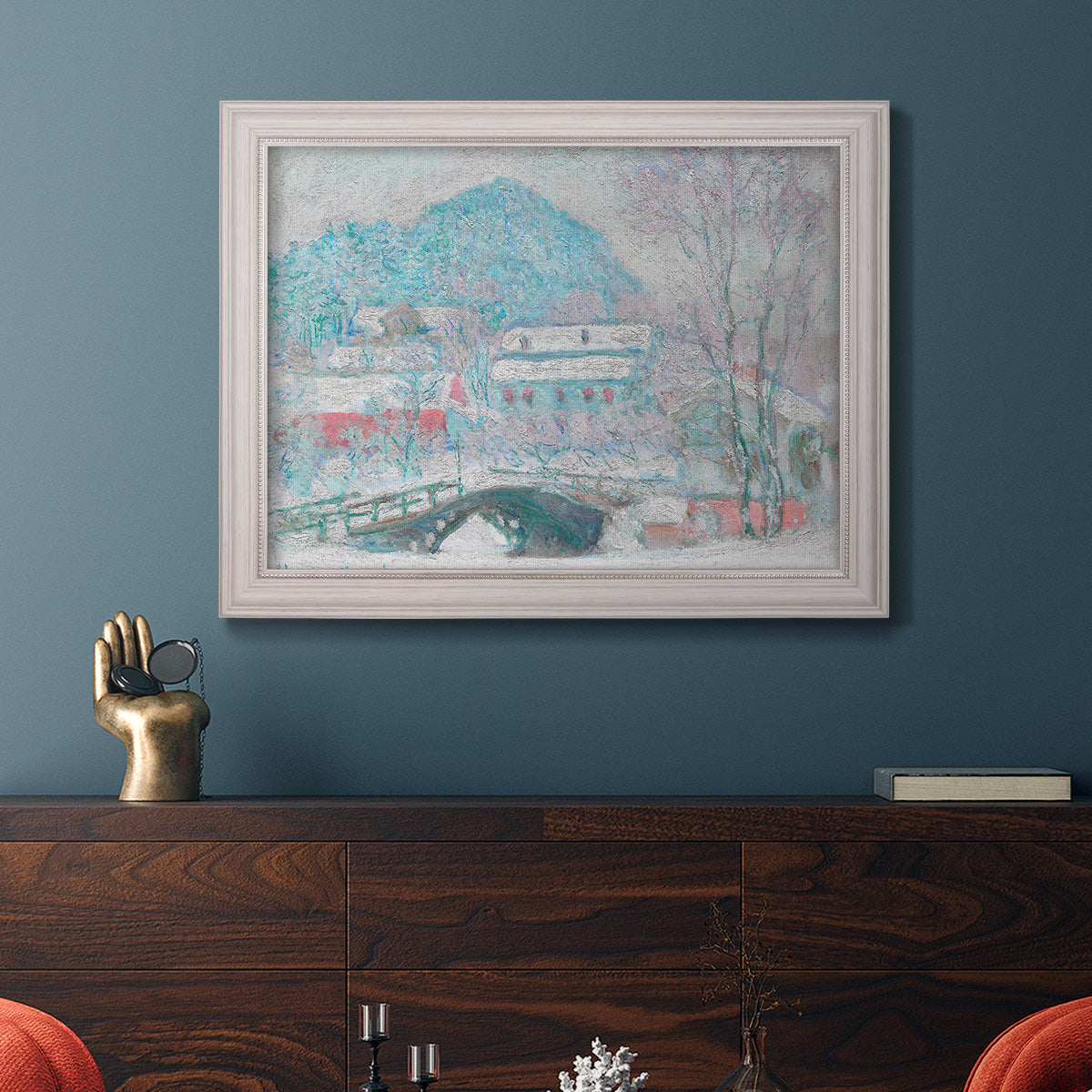 Impressionist coastal village landscape in Norway by Claude Monet in an ornate weathered white frame displayed in a dark-toned interior setting.