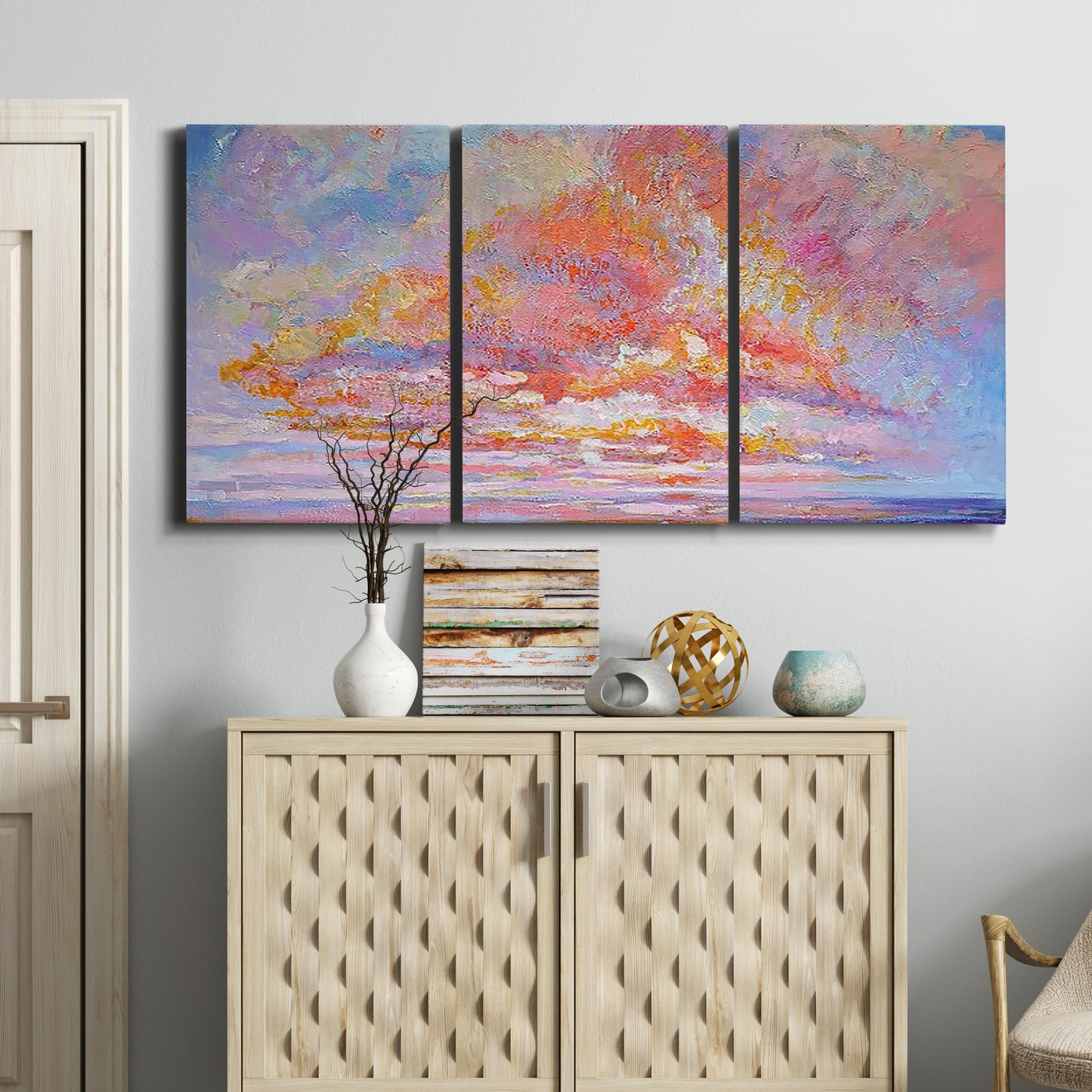 Three-panel canvas wall art featuring peaceful tropical inspired landscape, displayed above a cabinet in an entryway.