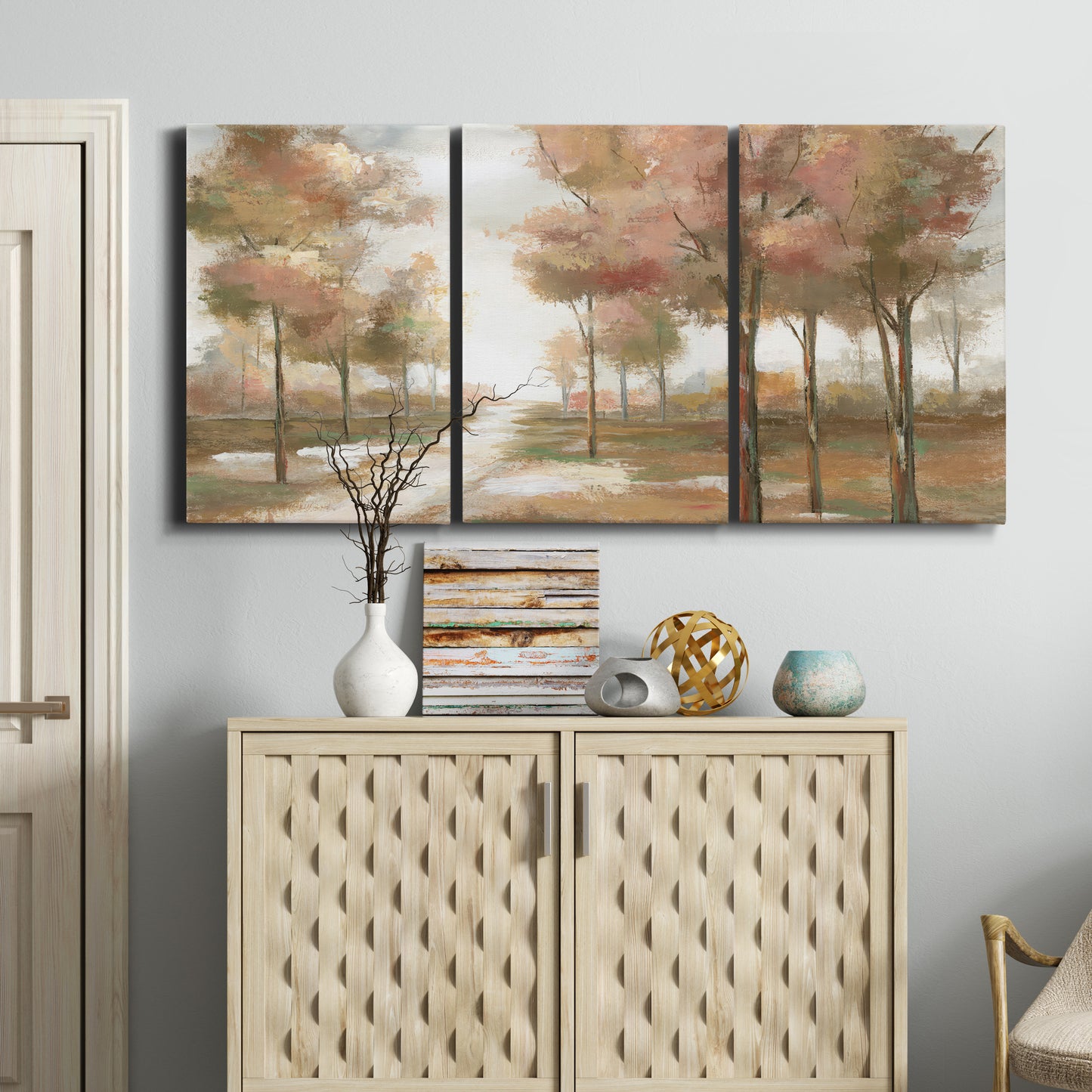 Three-panel canvas wall art featuring soft pastel park landscape scene, displayed above a cabinet in an entryway.