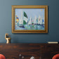 Coastal harbor watercolor painting in an ornate traditional gold frame displayed in a dark-toned interior setting.