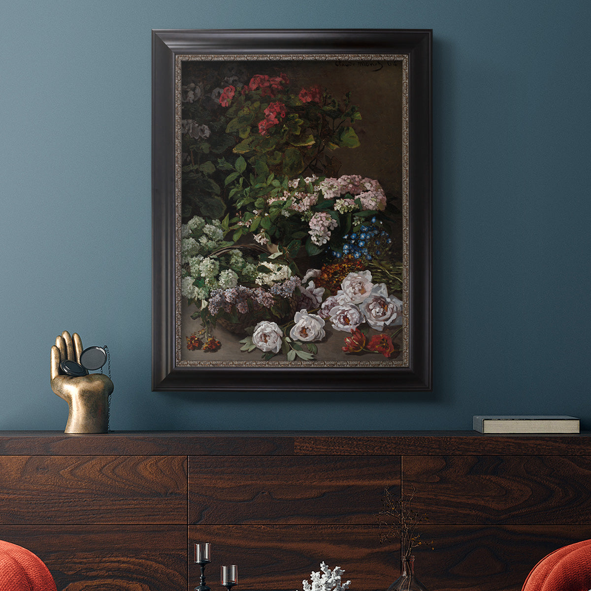 Early impressionist floral painting by Claude Monet in an ornate black frame with gilded inner detail displayed in a dark-toned interior setting.