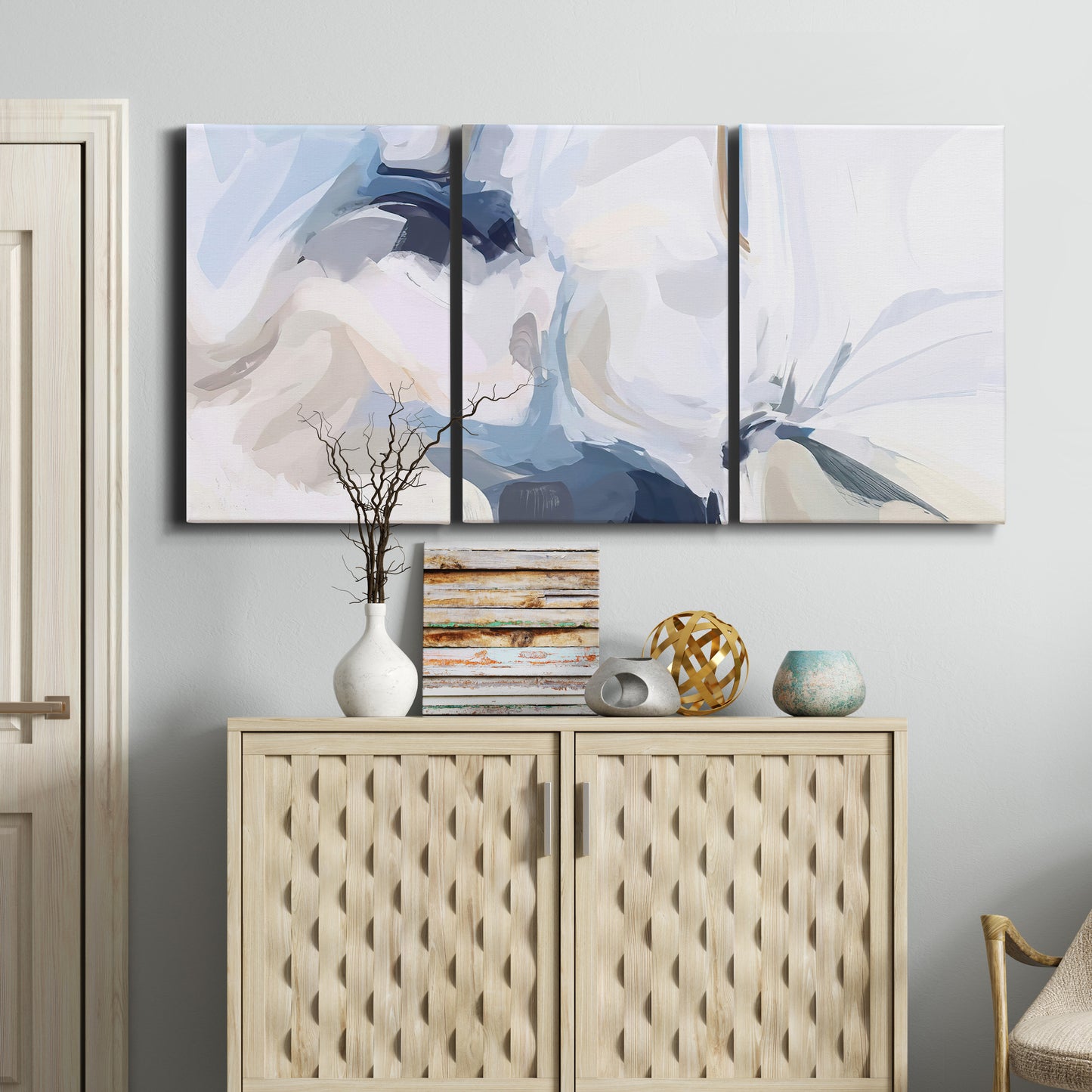 Three-panel canvas wall art featuring airy abstract movement composition, displayed above a cabinet in an entryway.