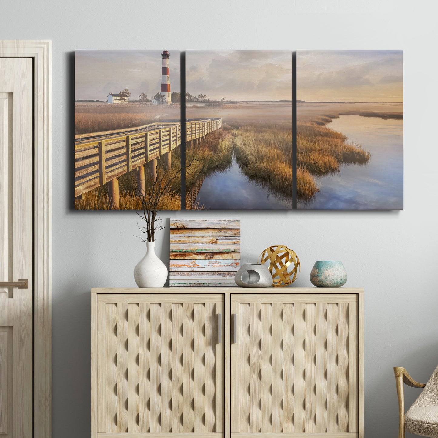 Three-panel canvas wall art featuring coastal path along dunes, displayed above a cabinet in an entryway.