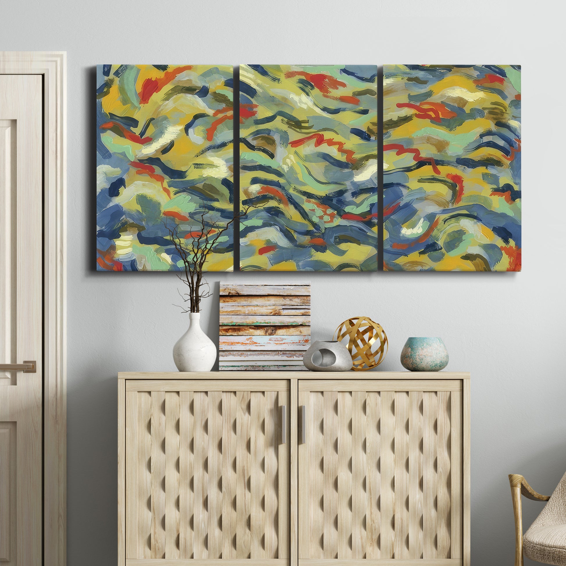 Three-panel canvas wall art featuring colorful abstract river like motion, displayed above a cabinet in an entryway.