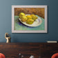 Impressionist still life with lemons by Vincent van Gogh in an ornate weathered white frame displayed in a dark-toned interior setting.