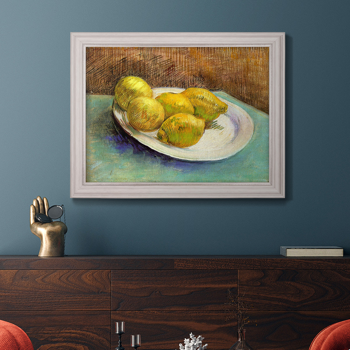 Impressionist still life with lemons by Vincent van Gogh in an ornate weathered white frame displayed in a dark-toned interior setting.