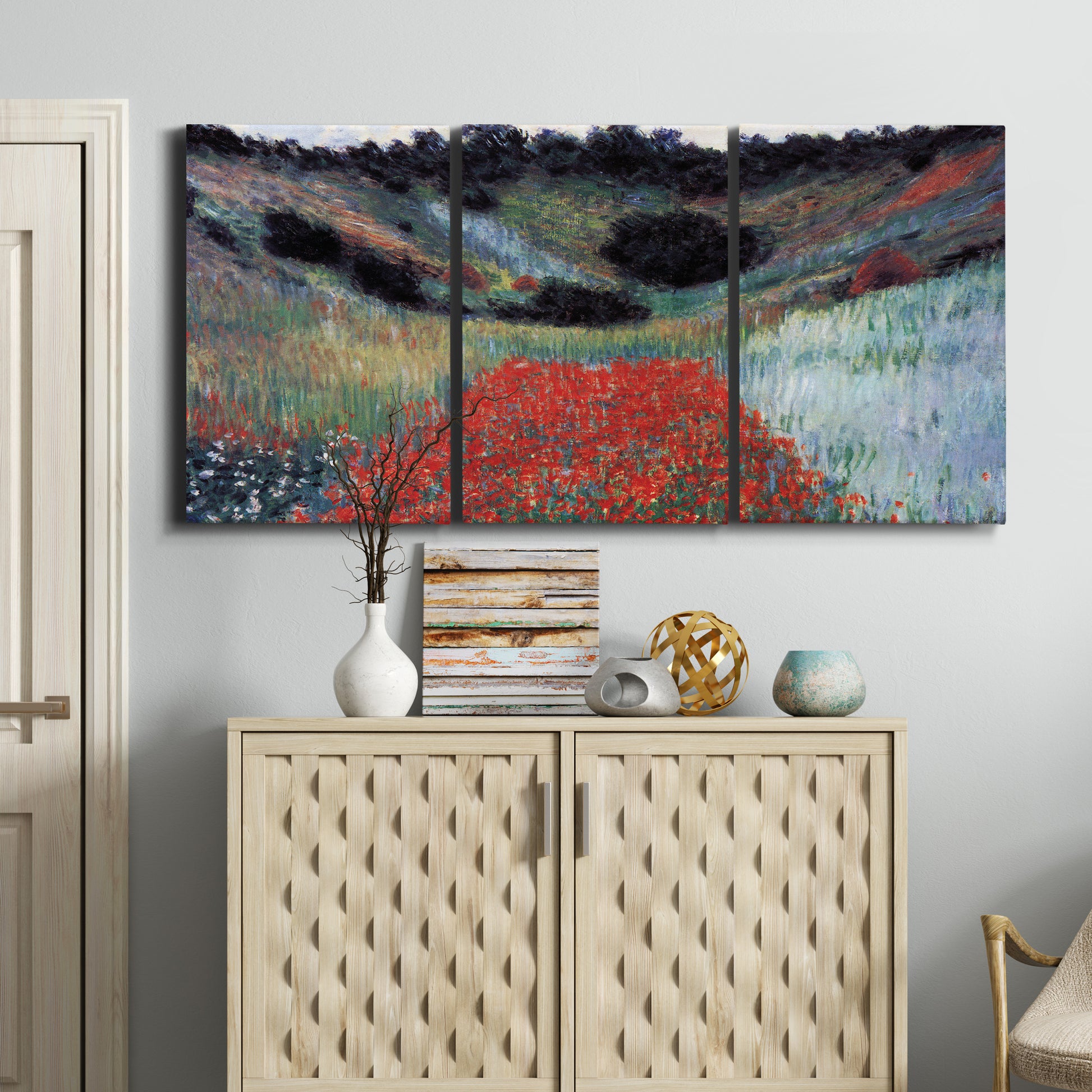 Three-panel canvas wall art featuring poppy field in shallow valley, displayed above a cabinet in an entryway.