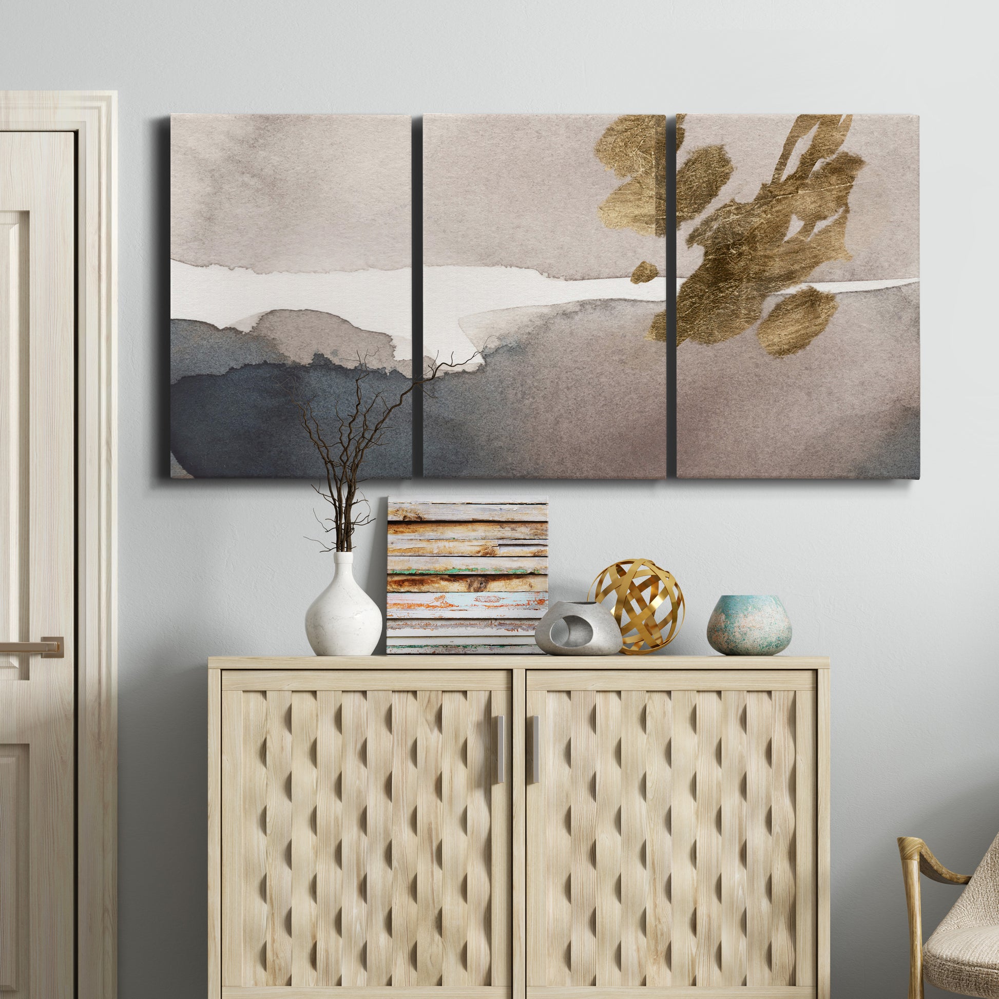 Three-panel canvas wall art featuring abstract watercolor with gold accents, displayed above a cabinet in an entryway.