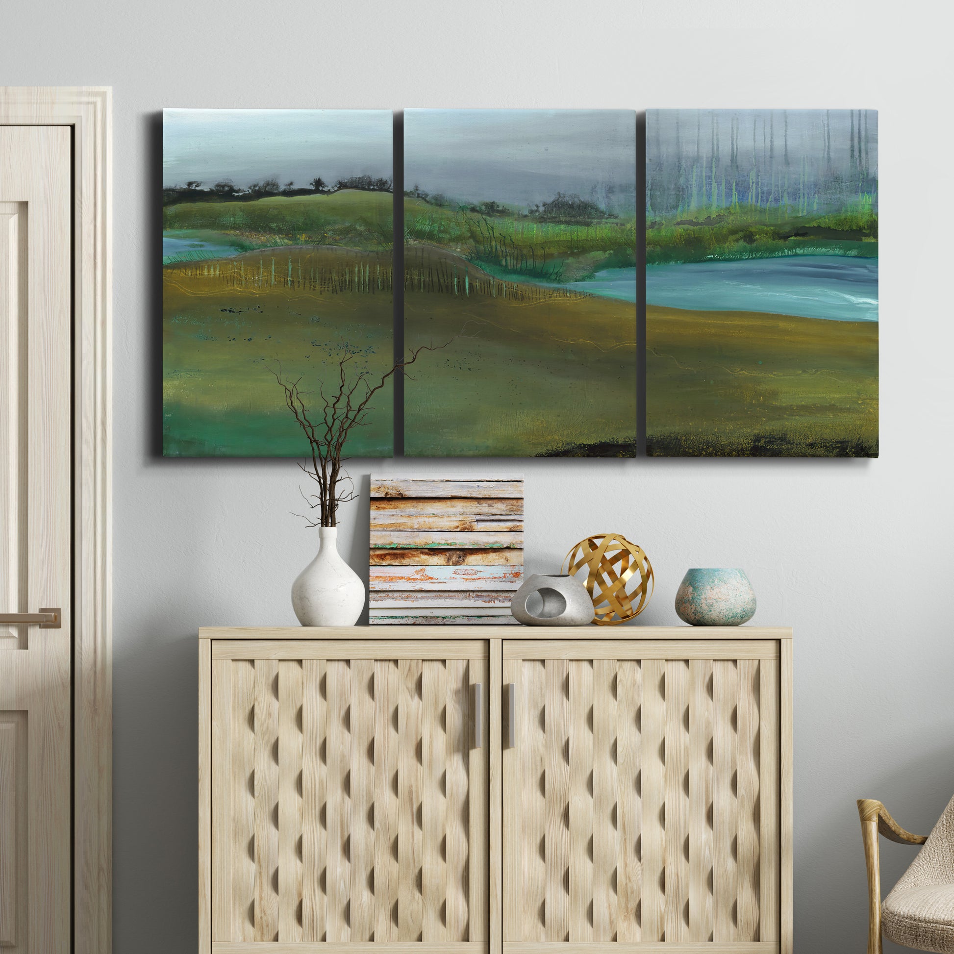 Three-panel canvas wall art featuring quiet contemplative landscape scene, displayed above a cabinet in an entryway.