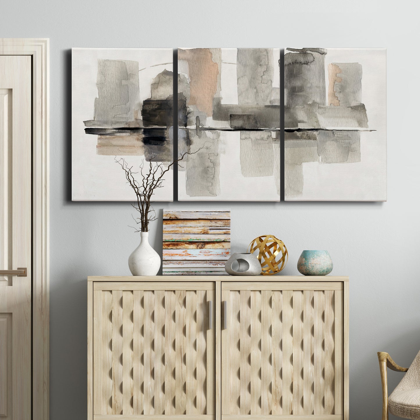 Three-panel canvas wall art featuring urban abstract watercolor oasis, displayed above a cabinet in an entryway.