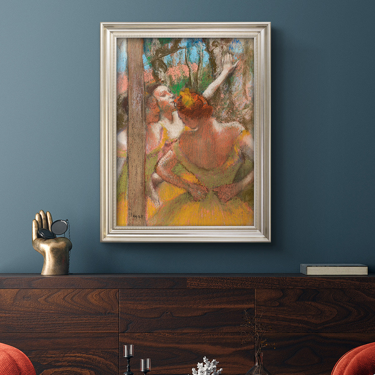 Impressionist ballet dancer composition by Edgar Degas in an ornate champagne frame displayed in a dark-toned interior setting.