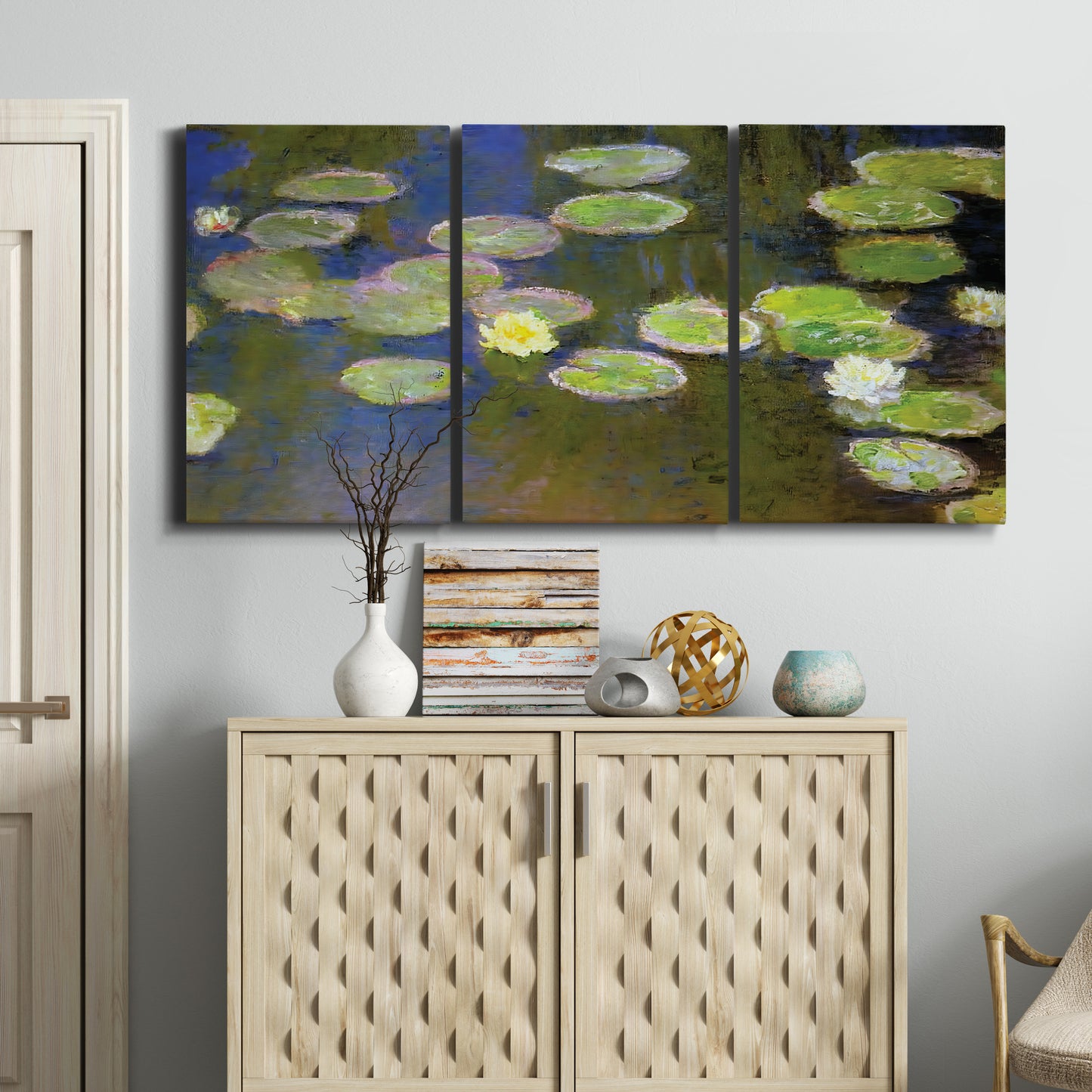 Three-panel canvas wall art featuring yellow and white water lilies, displayed above a cabinet in an entryway.