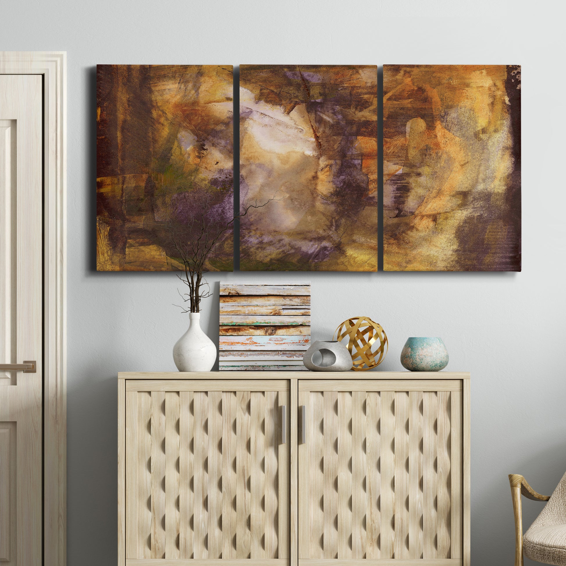 Three-panel canvas wall art featuring abstract architectural landscape, displayed above a cabinet in an entryway.