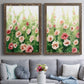 Set of two walnut barnwood framed canvas prints depicting paired luminous impressionistic floral paintings with loose blossoms, green stems, and sunlit watercolor texture above a sofa in a contemporary living room.