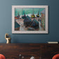 Impressionist coastal beach scene with boats by Claude Monet in an ornate weathered white frame displayed in a dark-toned interior setting.