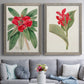 Set of two gray barnwood framed canvas prints depicting paired antique botanical plate illustrations with large green leaves, red blossoms, and archival cream paper above a sofa in a contemporary living room.