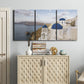 Three-panel canvas wall art featuring white buildings overlooking sea cliffs, displayed above a cabinet in an entryway.