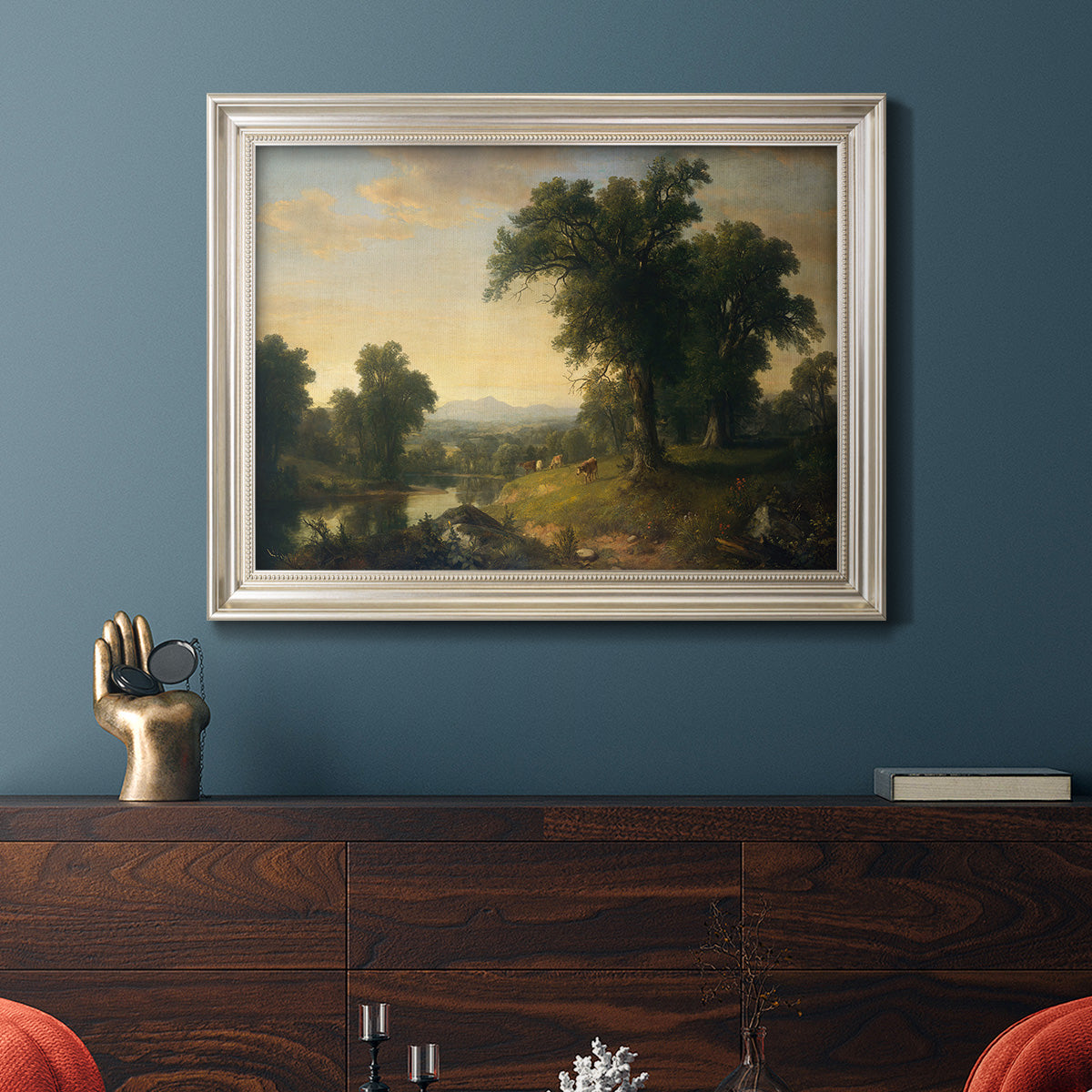 Traditional pastoral landscape painting by Asher Brown Durand in an ornate champagne frame displayed in a dark-toned interior setting.