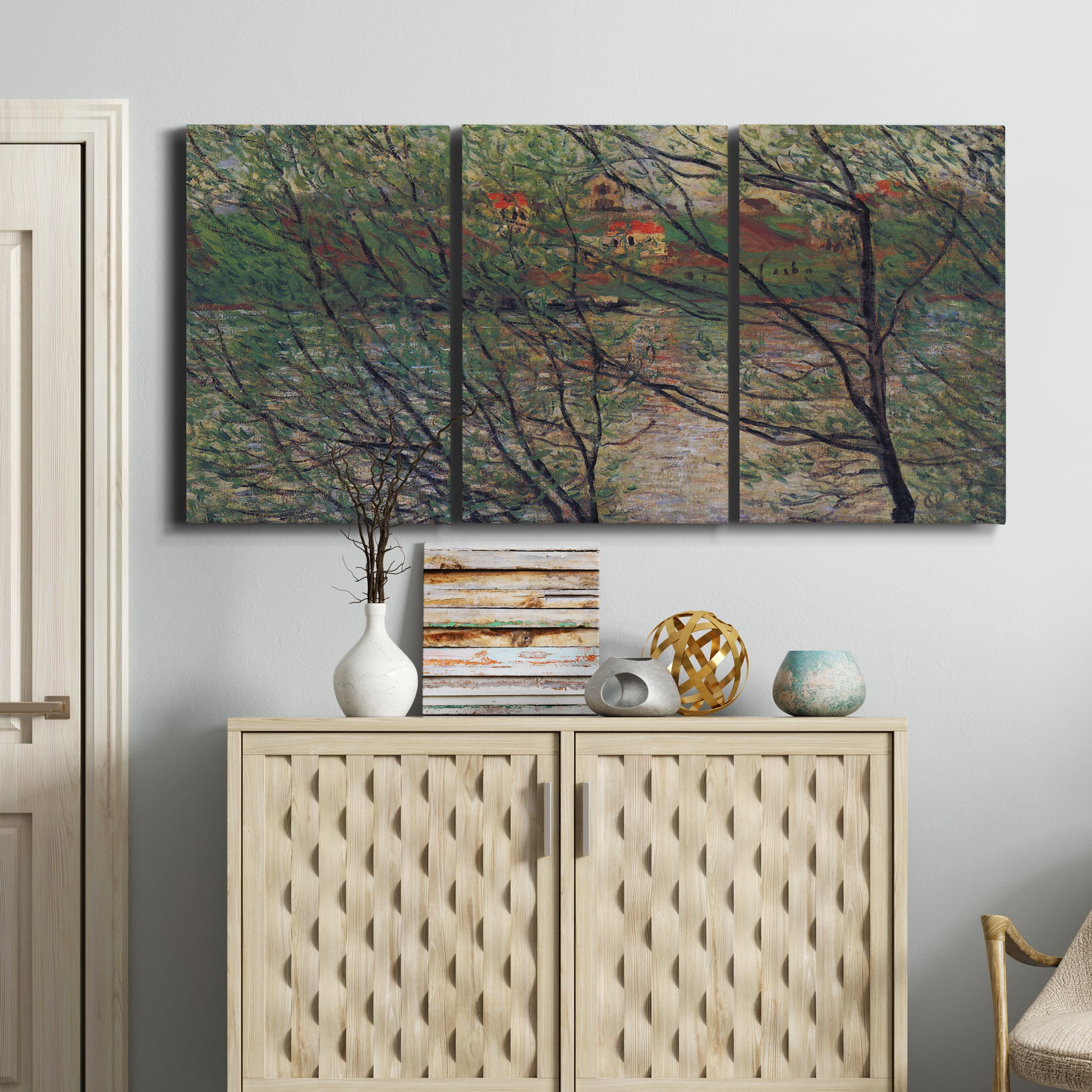 Three-panel canvas wall art featuring spring countryside with fresh foliage, displayed above a cabinet in an entryway.