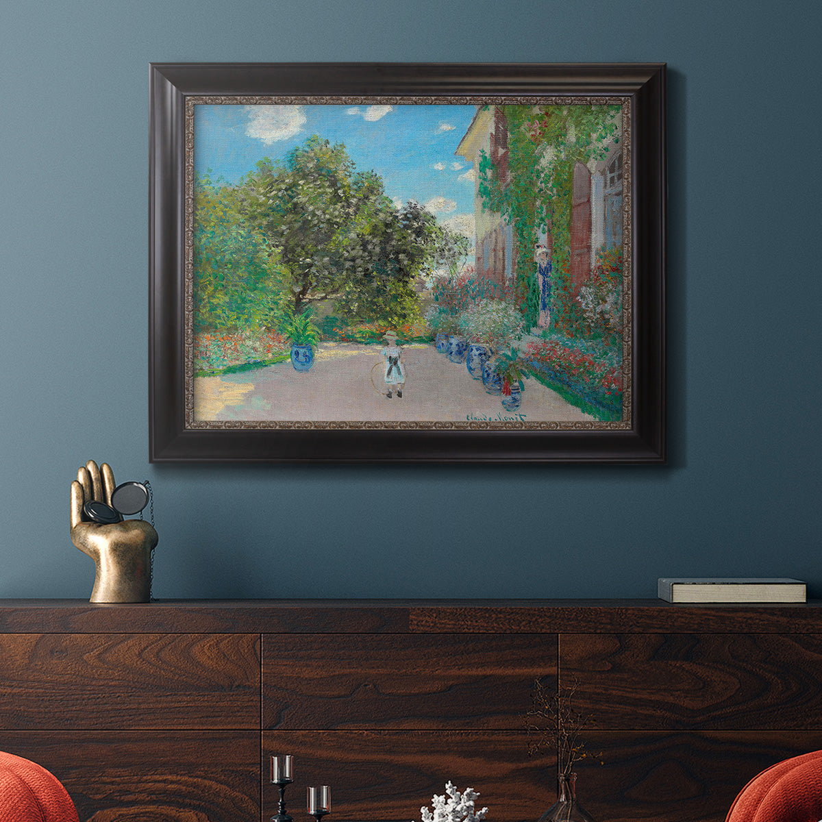 Impressionist residential landscape at Argenteuil by Claude Monet in an ornate black frame with gilded inner detail displayed in a dark-toned interior setting.